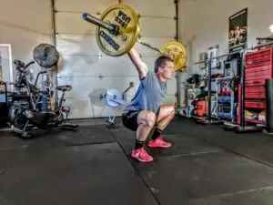 Crossfitter performing full range overhead squat for strength, flexibility, and power